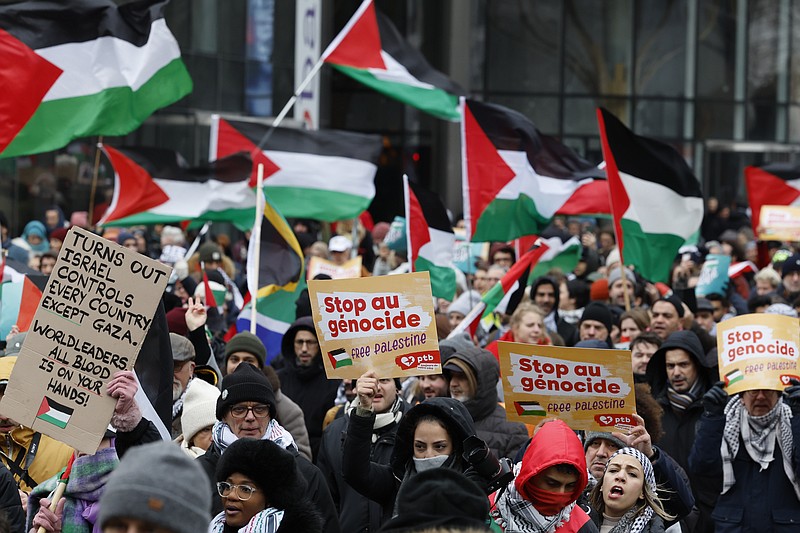 Demonstrators hold signs and wave flags during a pro-Palestinian rally in Brussels, Sunday, Jan 21, 2024. (AP Photo/Geert Vanden Wijngaert)