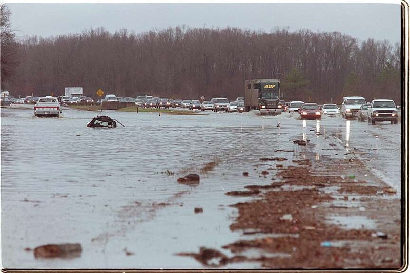 FILE - Motorists chug through high water on the southbound lanes of U.S. Hwy 67/167 just north of Jacksonville. (Arkansas Democrat-Gazette/RICK MCFARLAND)