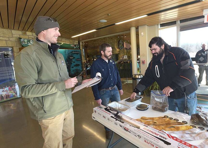 Blade (cq) Elmore (right) of Springdale weighs his three squirrels in the Big Squirrel Challenge with Levi Horrell (left) and Cody Wyatt, both with the Arkansas Game and Fish Commission. Elmore hunted near Sonora.
(NWA Democratd-Gazette/Flip Putthoff)