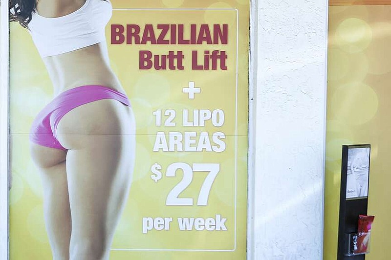 AP file
A window display advertises low-cost "Brazilian butt lift" cosmetic surgery procedures March 22, 2019, outside a clinic in Miami.