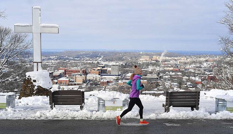 A runner passes the cross and the scenic overlook Thursday, Jan. 26, 2023, on Skyline Drive on Mount Sequoyah in Fayetteville.  (NWA Democrat-Gazette/Andy Shupe)