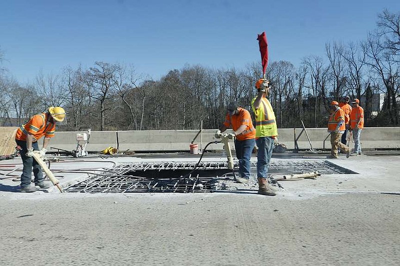 Arkansas Department of Transportation workers fix a large hole on a bridge near exit 9 of Interstate 440 in North Little Rock on Tuesday, Jan. 30, 2024. (Arkansas Democrat-Gazette/Thomas Metthe)