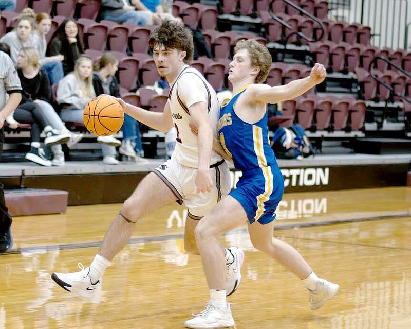 Photograph courtesy of Krystal Elmore Evan Allen of Siloam Springs (left) drives past a Mountain Home defender  on Friday night at the Panther Activity Center. Allen scored nine points for the Panthers.