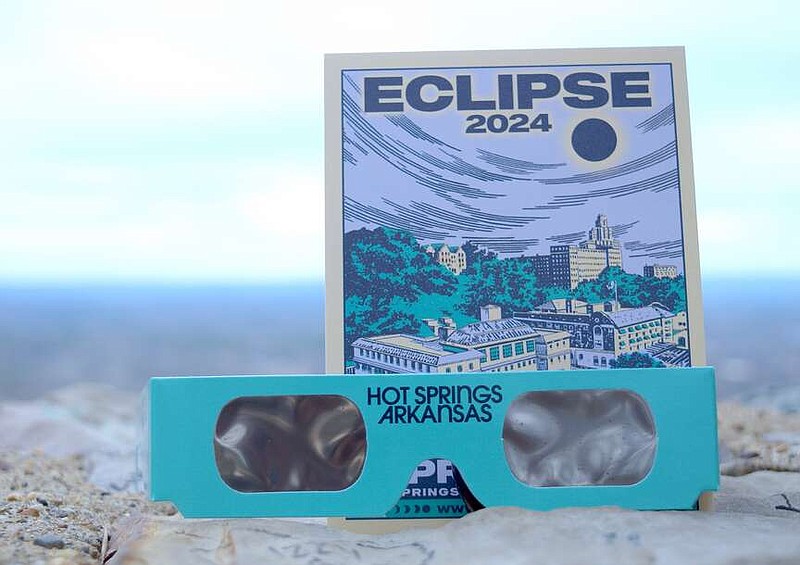 A flyer about the April 8 eclipse and a pair of eclipse glasses from Visit Hot Springs are shown sitting on Hot Springs Mountain. The glasses are available for purchase from local retailers. (The Sentinel-Record/Donald Cross)