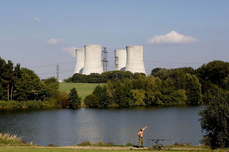 FILE - A man fishes with the towering Dukovany nuclear power plant in the background, in Dukovany, Czech Republic, Sept. 27, 2011. The Czech government said on Wednesday Jan. 31, 2024, it was expanding a public tender to build up to four nuclear reactors instead of one as the country's strives to become more energy independent and wean itself of fossil fuels.(AP Photo/Petr David Josek, File)