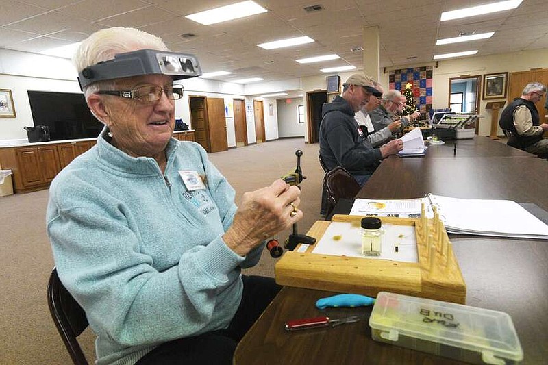 Luann Lawrence wraps thread around a hook Dec. 18 2023 while crafting a fishing fly at the Bella Vista Fly Tyers weekly tying class. The group offers classes for new and experienced tyers.
(NWA Democrat-Gazette/Flip Putthoff)