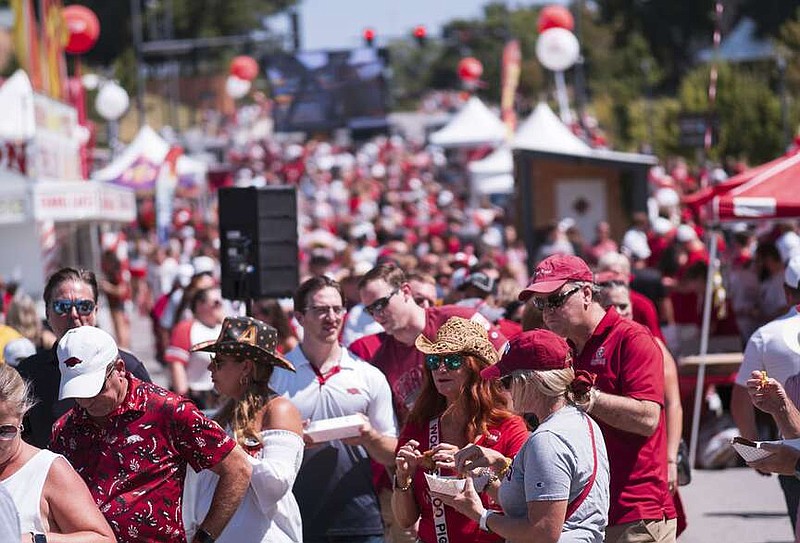 Fans eat lunch on Sept. 9 before the start of a Razorback football game at the Hogtown tailgate at Donald W. Reynolds Razorback Stadium in Fayetteville. The success of the football team can impact the hospitality sales tax revenue the city receives, but it's not the sole determinant, city and tourism officials say.

(File photo/NWA Democrat-Gazette/Charlie Kaijo)