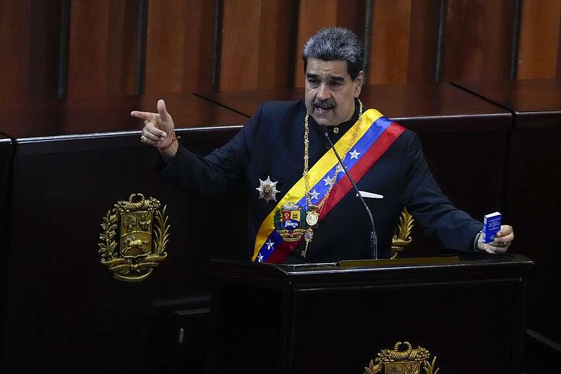 Venezuelan President Nicolas Maduro holds a small copy of his nation's constitution during ceremony marking the start of the judicial year Jan. 31, 2024, at the Supreme Court in Caracas, Venezuela. A secret memo obtained by The Associated Press details a covert operation by the U.S. Drug Enforcement Administration that sent undercover operatives into Venezuela to record and build drug-trafficking cases against the country's leadership, including Venezuelan President Nicolás Maduro. (AP Photo/Ariana Cubillos, File)