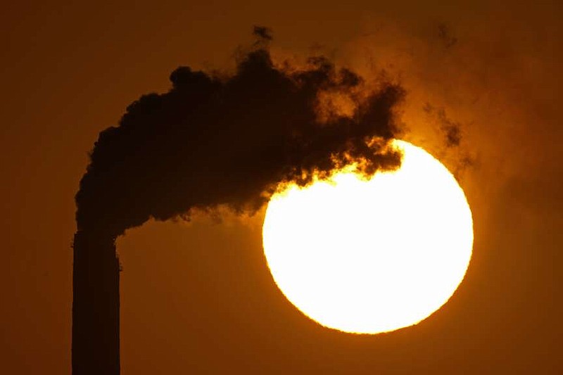 FILE - Emissions rise from the smokestacks at the Jeffrey Energy Center coal power plant as the suns sets Sept. 18, 2021, near Emmett, Kan. The Biden administration is setting tougher standards for deadly soot pollution, saying that reducing fine particle matter from tailpipes, smokestacks and other industrial sources could prevent thousands of premature deaths a year. (AP Photo/Charlie Riedel, File)