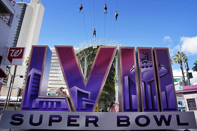 People ride a zip line above a sign for the Super Bowl ahead of the Super Bowl 58 NFL football game, Friday, Feb. 2, 2024, in Las Vegas. Las Vegas is scheduled to host the Super Bowl 58 on Sunday, Feb. 11, 2024. (AP Photo/John Locher)