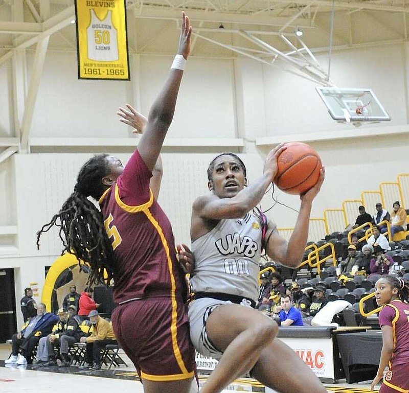 UAPB guard Zaay Green attacks the rim while guarded by Bethune-Cookman center Kayla Clark during a Jan. 22 women's basketball game at H.O. Clemmons Arena in Pine Bluff. (Special to the Commercial/William Harvey)