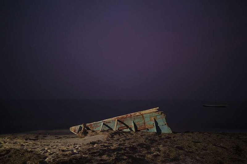FILE - The wreck of a traditional Mauritanian fishing boat, known as a pirogue, also used by migrants to reach Spain's Canary Islands, sits on a beach near Nouadhibou, Mauritania, on Dec. 2, 2021. The head of the EU's executive branch, Commission President Ursula von der Leyen, and Spain's Prime Minister Pedro Sánchez are visiting the African nation of Mauritania to discuss migration, security and energy with the African nation's President Mohamed Ould Ghazouani. The visit takes amid a surge in the number of migrants embarking on a dangerous Atlantic crossing from the coast of Mauritania to Spain's Canary Islands. (AP Photo/Felipe Dana)