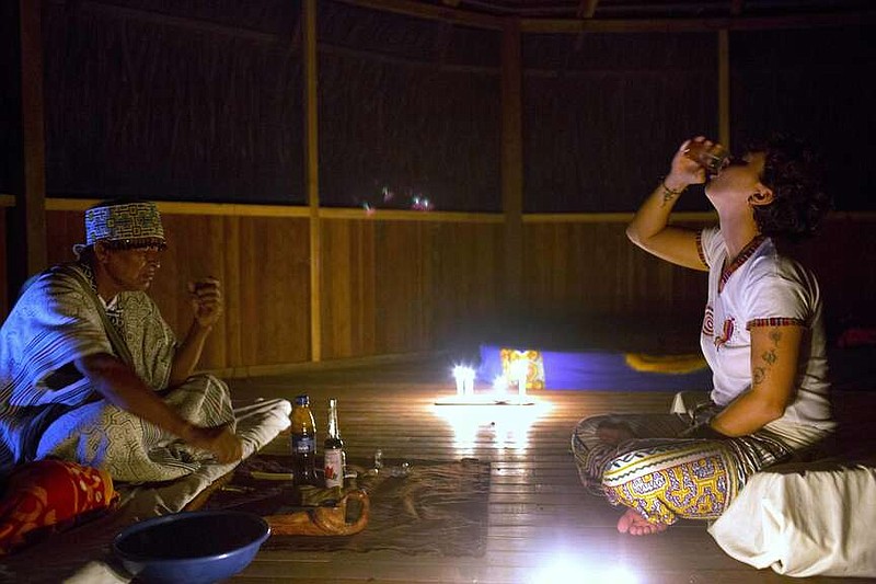 FLE - Italian national Pamela Moronci drinks ayahuasca, monitored by Shaman Pablo Flores, during a session in Nuevo Egipto a remote village in the Peruvian Amazon on May 6, 2018. "The plant told me I had a problem in my ovaries that I was not aware of, and that is what I am working on now," she said. (AP Photo/Martin Mejia, File)