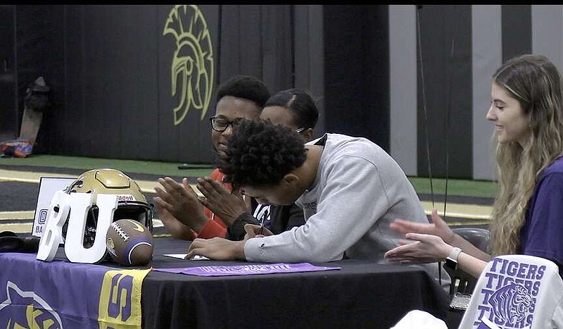 Hot Springs senior Kendall Williams signs his letter of intent to play football at Ouachita Baptist University this fall, Wednesday, at the Hot Springs World Class High School indoor practice facility. (The Sentinel-Record/Donald Cross)