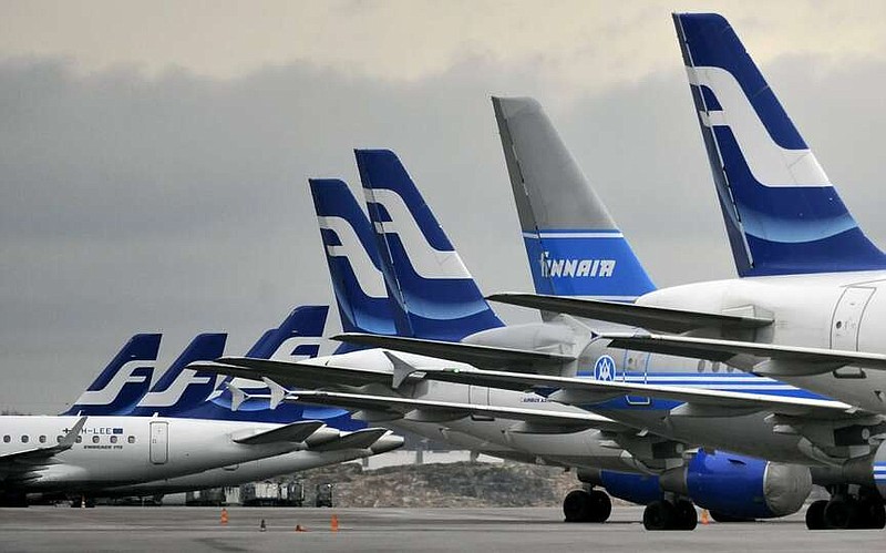 FILE - Passenger planes of the Finnish national airline company Finnair stand on the tarmac at Helsinki international airport, Helsinki on Nov. 16, 2009.  Finnish national carrier is asking aircraft passengers and their hand luggage to voluntarily hop on a scale to update the standard weights. The anonymous weighing of passengers takes place before boarding onto European and long-haul flights at departure gates at the Helsinki airport.(Markku Ulander/Lehtikuva via AP, File)