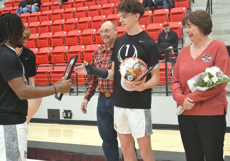 Annette Beard/Pea Ridge TIMES
Smiles, hugs, tears were abundant as junior team members presented gifts to senior basketball players Friday, Feb. 9, on Senior Night. Sophomore Zion Whitmore presents a gift to senior Ben Wheeler. For more photographs, go to the PRT gallery at https://tnebc.nwaonline.com/photos/.