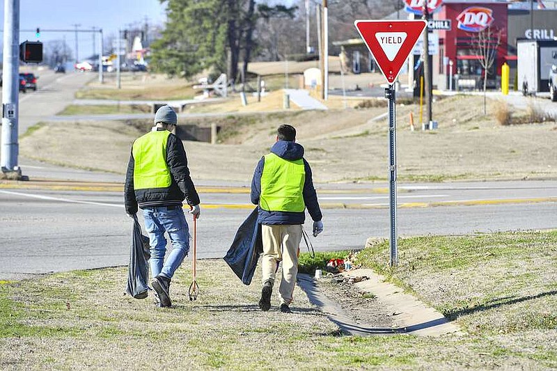 Two men collect trash Feb. 17 as part of Keep Van Buren Beautiful's Community Service Worker Program in Van Buren. The program reported that 212 participants filled 1,424 30-gallon size trash bags with items picked up off city streets in 2023. The program's workers are assigned by District Court Judge Charles Baker, and work a certain amount of time instead of paying a fine for misdemeanor crimes. Visit rivervalleydemocratgazette.com/photo for today's photo gallery.

(River Valley Democrat-Gazette/Hank Layton)