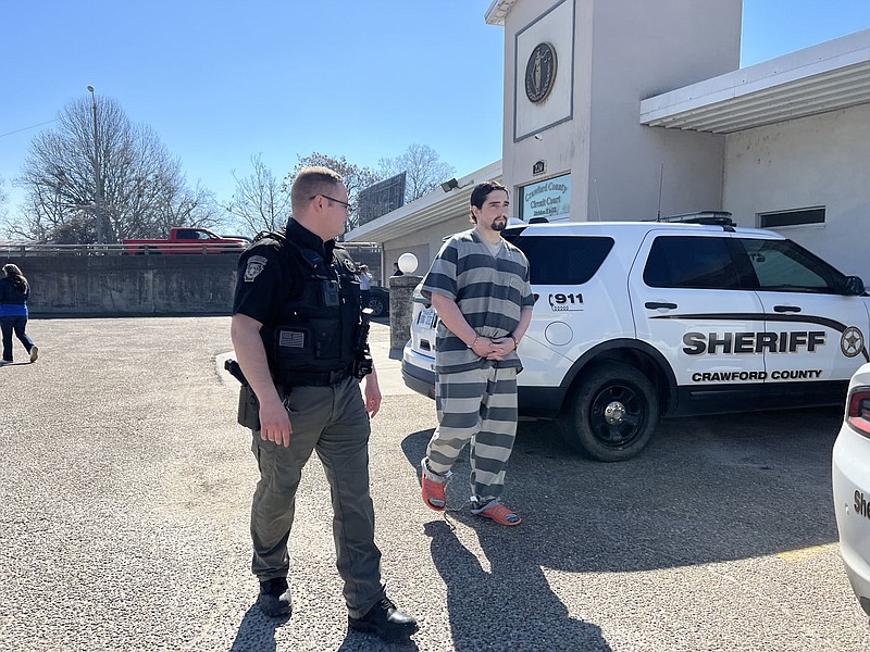 Eathan Alan Cypert, right, is escorted out of the Crawford County Courthouse Annex in Van Buren by a Crawford County sheriff's deputy, left, following his hearing Tuesday. 
(River Valley Democrat-Gazette/Thomas Saccente)