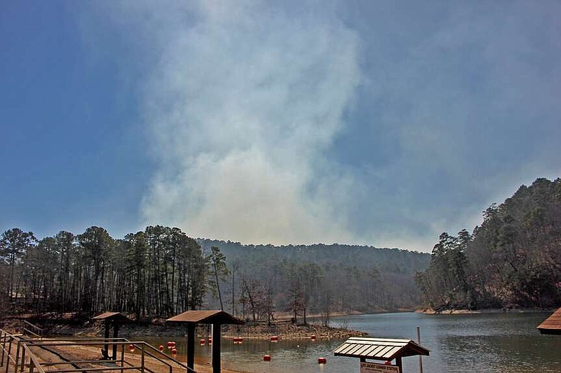 Smoke rises over Bear Mountain and Lake Ouachita as seen from the boat ramp at Brady Mountain Recreation Area. The U.S. Forest Service has started a series of prescribed burns around the lake. (The Sentinel-Record/James Leigh)