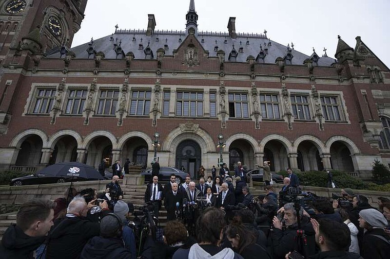 Riyad Al-Maliki, minister of Foreign Affairs of the Palestinian National Authority, center, gives a statement outside the Peace Palace after the United Nations' highest court opened historic hearings, in The Hague, Netherlands, Monday, Feb. 19, 2024. The Palestinian foreign minister has accused Israel of apartheid and urged the United Nations' top court to declare that Israel's occupation of lands sought for a Palestinian state is illegal. If the situation endures, the Palestinians say that any hope for a two-state future will die. The allegation came at the start of historic hearings into the legality of Israel's 57-year occupation of lands sought for a Palestinian state. (AP Photo/Peter Dejong)