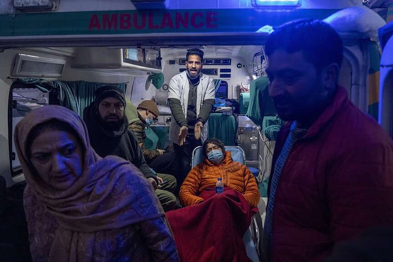 A paramedic gestures as he attends to an injured Russian skier in an ambulance in Tangmarg, near Gulmarg, a popular skiing destination in Indian controlled Kashmir, Thursday, Feb. 22, 2024. Officials say that one Russian skier was killed and four rescued when an avalanche hit Gulmarg on Thursday. (AP Photo/Dar Yasin)