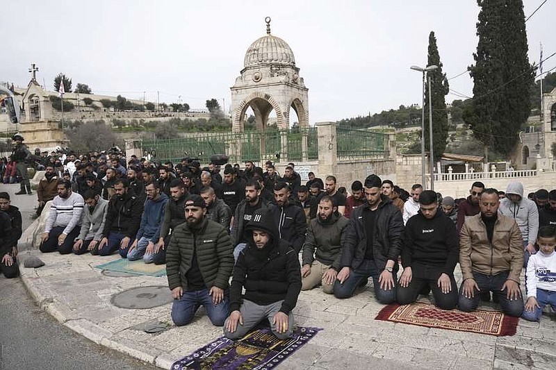 Palestinian Muslim worshipers who were prevented from entering the Al-Aqsa Mosque compound, pray outside Jerusalem's Old City as Israeli forces stand guard, Friday, Feb. 23, 2024. (AP Photo/Mahmoud Illean)