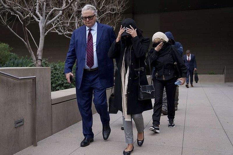 David Chesnoff, left, defense attorney for Alexander Smirnov, walks out of federal court with a group of unidentified people, Monday, Feb. 26, 2024, in Los Angeles. A former FBI informant charged with fabricating a multimillion-dollar bribery scheme involving President Joe Biden's family must remain behind bars while he awaits trial, a judge ruled Monday, reversing an earlier order releasing the man.  (AP Photo/Eric Thayer)
