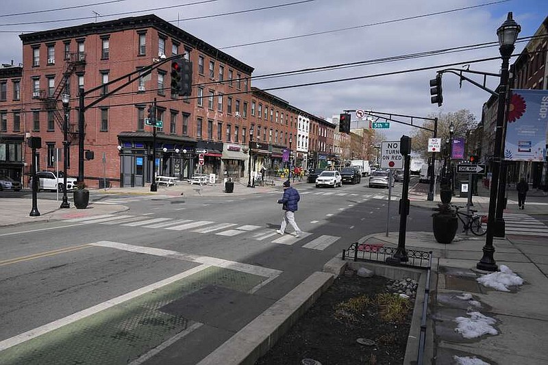 Pedestrians cross the street at the intersection of Washington and 5th in Hoboken, N.J., Thursday, Feb. 22, 2024. This intersection has a planter which doubles as a curb extender, bottom center, preventing parking near the intersection and increasing visibility for pedestrians. (AP Photo/Seth Wenig)