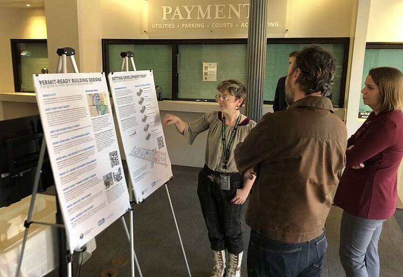 People gather Tuesday around an informational display of Fayetteville's planned permit-ready home design program. The City Council reviewed design standards for the program later that day.

(NWA Democrat-Gazette/Stacy Ryburn)