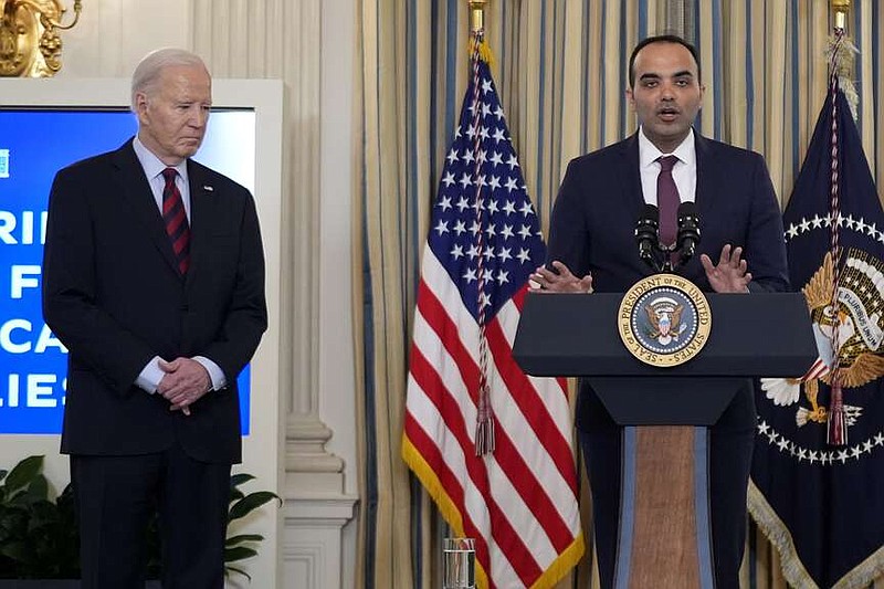 Rohit Chopra, director of the Consumer Financial Protection Bureau, speaks as President Joe Biden, left, looks on during a meeting with Biden's Competition Council to announce new actions to lower costs for families in the State Dining Room of the White House in Washington, Tuesday, March 5, 2024. (AP Photo/Andrew Harnik)