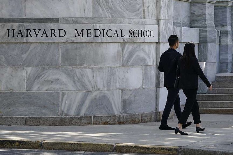 FILE - Pedestrians walk towards the Harvard Medical School, Aug. 18, 2022, in Boston.  Jeremy Pauley has pleaded guilty to federal charges stemming from the theft and sale of human body parts taken from Harvard Medical School and an Arkansas mortuary, Friday, Sept. 8, 2023. (AP Photo/Charles Krupa, File)