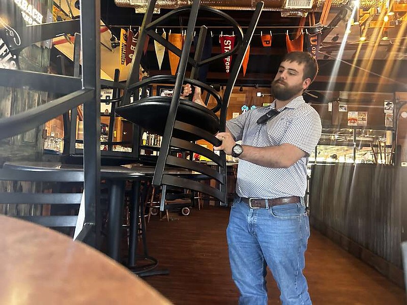 Destin Steitler, co-owner of Duke Bar & Grill, formerly 67 Landing, places a chair on a table Wednesday, March 6, 2024, at the venue in Texarkana, Texas. Duke Bar & Grill will have an Old West theme. It will open April 20. (Staff Photo by Sharda James)