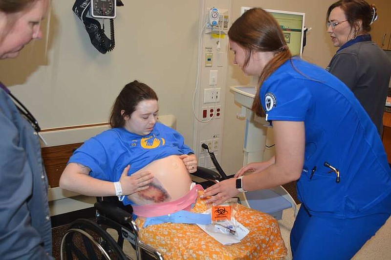 Marc Hayot/Herald-Leader John Brown University nursing student Erin Pianalto wraps the ‘belly' of Hannah Kintzel during a mass casualty simulation on March 8 at John Brown University's Health and Education building.