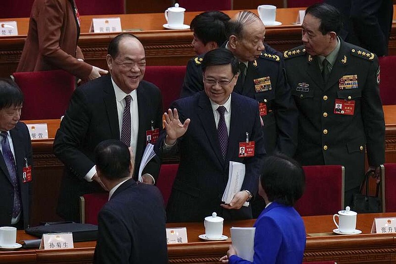 Hong Kong Chief Executive John Lee, center, waves to delegates after the opening session of the National People's Congress (NPC) at the Great Hall of the People in Beijing, Tuesday, March 5, 2024. (AP Photo/Andy Wong)