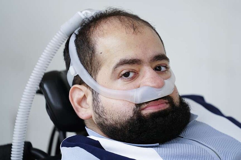 Temple University doctoral student Jaggar DeMarco poses for a photograph while utilizing a battery powered ventilator in Philadelphia, Wednesday, March 6, 2024. DeMarco waited more than three years to get his second ventilator from his health insurer. “Breathing is not a luxury," he said. “It's really the bare minimum, and that's what we're asking for.” (AP Photo/Matt Rourke)