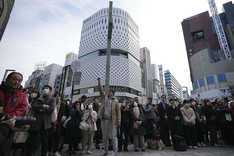 Bystanders gather when an annual tribute started at 2:46 p.m. for the victims of a 2011 disaster Monday, March 11, 2024, in Tokyo. Japan on Monday marked the 13th anniversary of the massive earthquake, tsunami and nuclear disaster that struck Japan's northeastern coast. (AP Photo/Eugene Hoshiko)