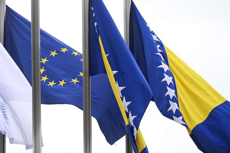 European Union flag flutters next to the flag of Bosnia and Herzegovina in front of the Council of Ministers building in Sarajevo, Bosnia-Herzegovina, Tuesday, March 12, 2024. The European Union's executive arm will recommend that member countries open accession negotiations with Bosnia-Herzegovina, European Commission President Ursula von der Leyen said Tuesday, despite lingering ethnic divisions in the Western Balkan country. (AP Photo/Armin Durgut)