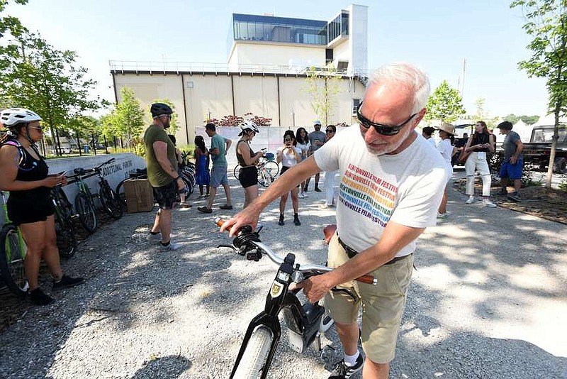 Tom Hoehn, a Bentonville Film Festival volunteer, explains how his e-bike works June 21, 2022, before a guided art-themed bike ride in conjunction with the festival.
(File Photo/NWA Democrat-Gazette/Flip Putthoff)