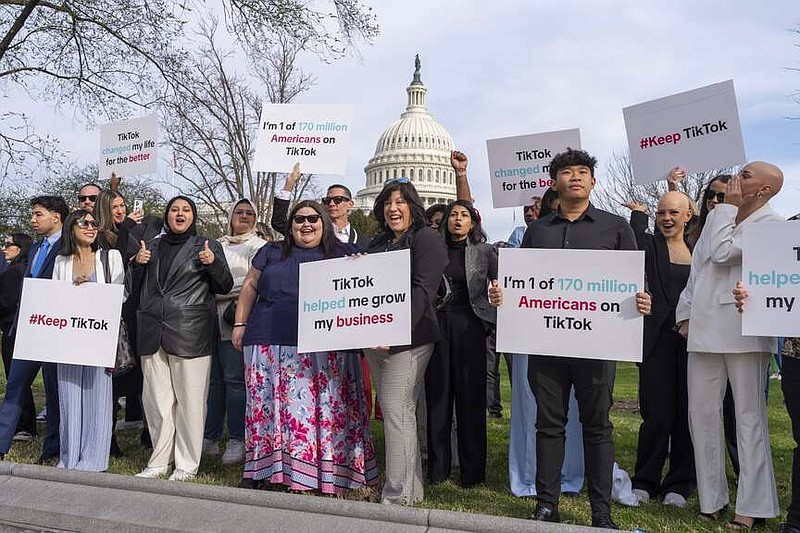 Devotees of TikTok cheer their support to passing motorists at the Capitol in Washington, before the House passed a bill that would lead to a nationwide ban of the popular video app if its China-based owner doesn't sell, Wednesday, March 13, 2024. Lawmakers contend the app's owner, ByteDance, is beholden to the Chinese government, which could demand access to the data of TikTok's consumers in the U.S. (AP Photo/J. Scott Applewhite)