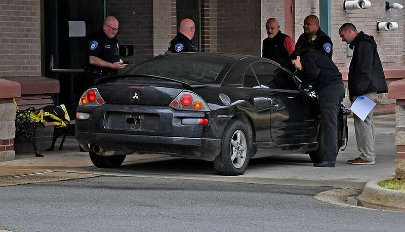 Hot Springs police examine a black 2003 Mitsubishi Eclipse at the police department on March 7. The vehicle was suspected of being involved in a hit-and-run collision. (The Sentinel-Record/Lance Brownfield)