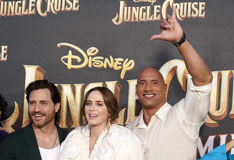 FILE - Dwayne Johnson, right, a cast member in "Jungle Cruise," flashes the Hawaiian "shaka" hand sign as he poses with fellow cast members Edgar Ramirez, left, and Emily Blunt at the world premiere of the film, July 24, 2021, at Disneyland in Anaheim, Calif. Hawaii's “shaka” hand sign is sometimes known as the “hang loose” gesture associated with surf culture. But it was a fixture of daily life in the islands long before it caught on in California, Brazil and beyond. (AP Photo/Chris Pizzello, File)