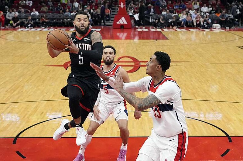 Houston Rockets' Fred VanVleet (5) drives toward the basket as Washington Wizards' Kyle Kuzma (33) defends during the first half of an NBA basketball game Thursday, March 14, 2024, in Houston. (AP Photo/David J. Phillip)