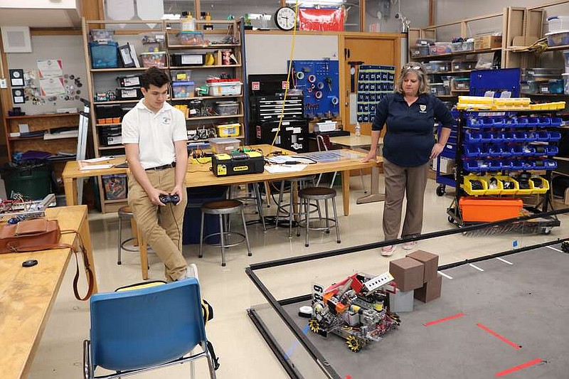 Anna Campbell/News Tribune
Helias Catholic sophomore Cody Mackey controls the RoboCrusaders' robot using an analog video game controller while teacher Melissa Rockers looks on.