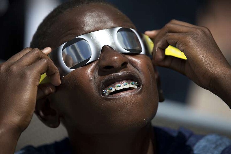 Blake Davis, 10, of Coral Springs, Fla., looks through solar glasses as he watches the eclipse, Monday, Aug. 21, 2017, at Nova Southeastern University in Davie, Fla. After April 8, 2024, there won't be another U.S. eclipse, spanning coast to coast, until 2045. That one will stretch from Northern California all the way to Cape Canaveral, Florida. (AP Photo/Wilfredo Lee, File)