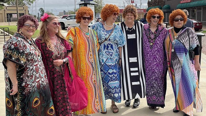 Participants in a Mrs. Roper Romp pose for a photo Saturday, March 16, 2024, on the Arkansas-Texas state line in downtown Texarkana. Dozens of women dressed as "Three's Company" character Helen Roper to enjoy brunch and an afternoon of playful fun. (Staff photo by Karl Richter)