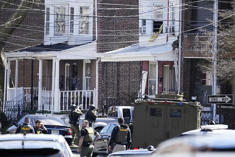 Police surround a home in Trenton, N.J., Saturday, March 16, 2024. A suspect has barricaded himself in the home and was holding hostages after shooting three people to death in suburban Philadelphia. (AP Photo/Matt Rourke)