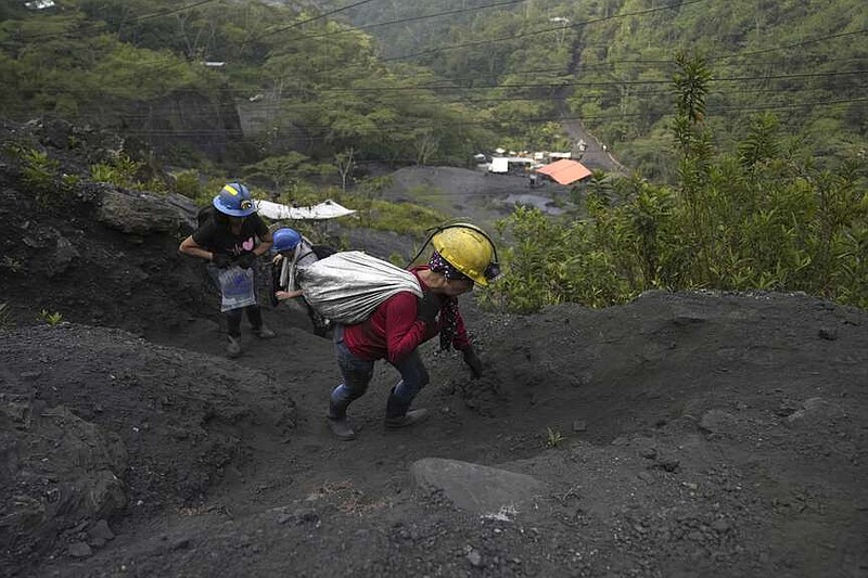 Deisy Alexa Gallo hauls a sack of rocks, drilled from an informal mine, to be washed and sifted through in search of emeralds, near the town of Coscuez, Colombia, Thursday, Feb. 29, 2024.  .(AP Photo/Fernando Vergara)