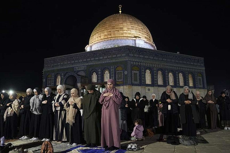 Muslim worshippers perform "tarawih," an extra lengthy prayer held during the Muslim holy month of Ramadan, next to the Dome of Rock at the Al-Aqsa Mosque compound in the Old City of Jerusalem, Saturday, March 16, 2024. (AP Photo/Mahmoud Illean)