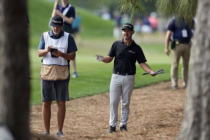 Brian Harman, center, gestures as he talks to his caddie Scott Tway from the rough on the 16th fairway during the final round of The Players Championship golf tournament Sunday, March 17, 2024, in Ponte Vedra Beach, Fla. (AP Photo/Lynne Sladky)