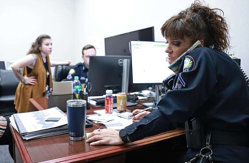 Lisa Nava, Little Rock Police Department Community Response Team member, works the phones at the team's office in downtown Little Rock during a case involving an individual needing assistance Friday, March 8, 2024. (Arkansas Democrat-Gazette/Colin Murphey)